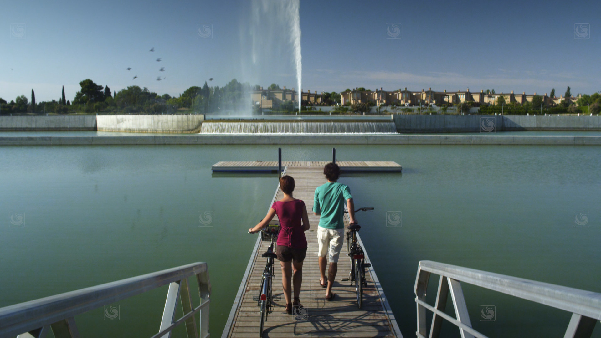Videoframe from a promotional video of Saragossa, showing a young couple next to an artificial pond